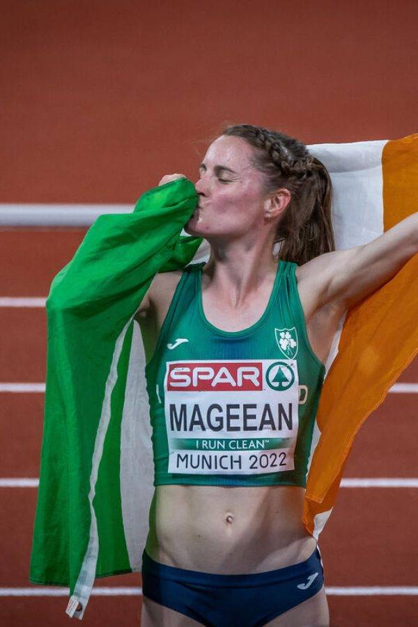 Athlete Ciara Mageean kisses the Irish flag, wearing a green SPAR top at Munich 2022.