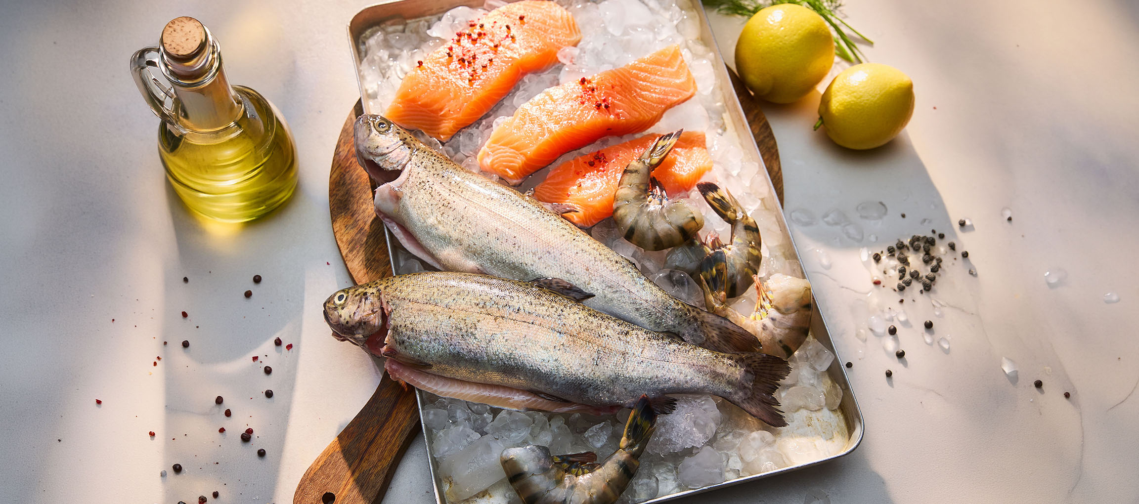 Fresh fish and seafood on ice, with lemons and oil.