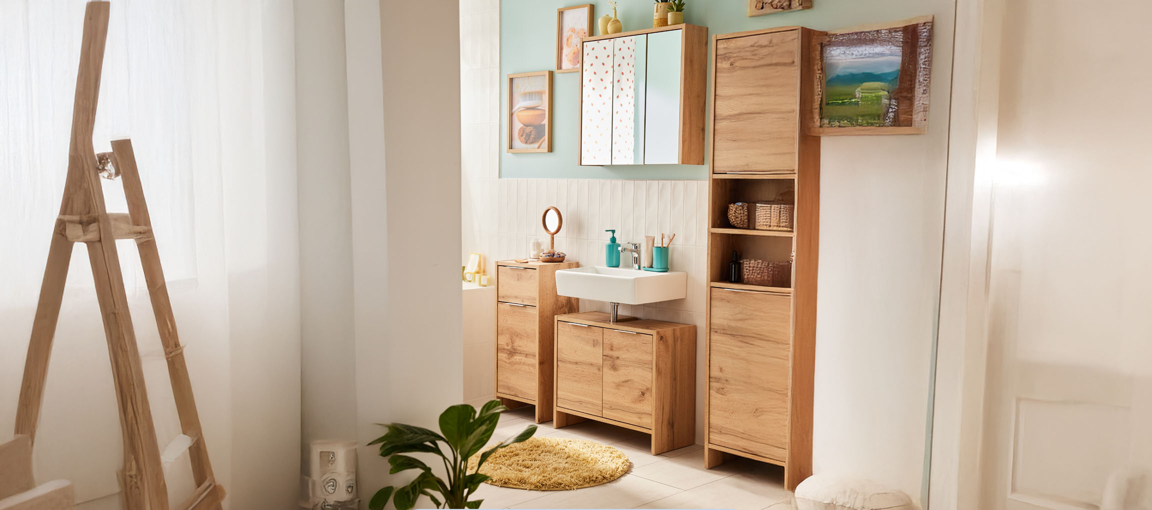 Modern bathroom with light wood furniture, white sink, and mirror.