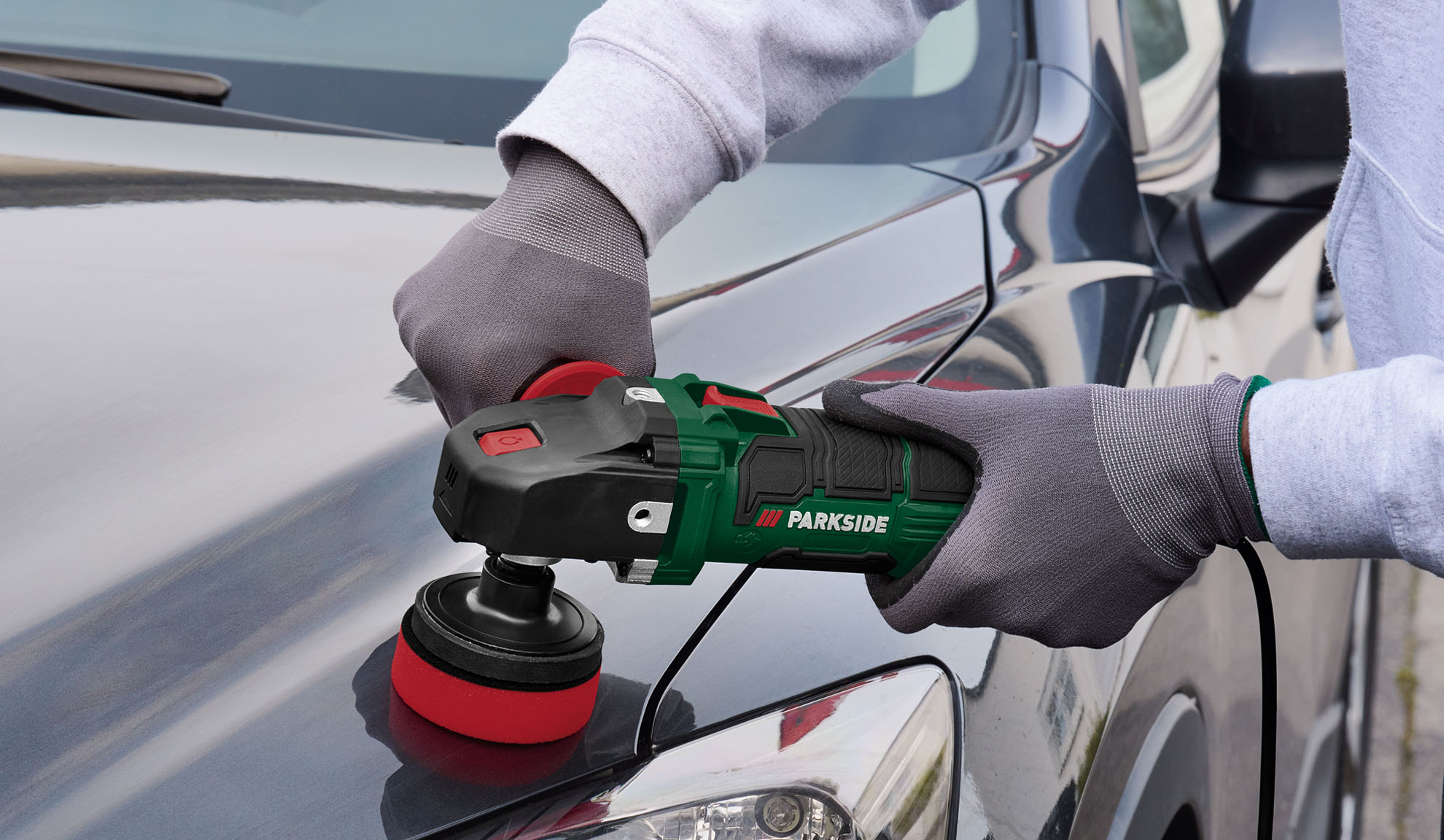 A person polishing a car's hood with a Parkside polisher.