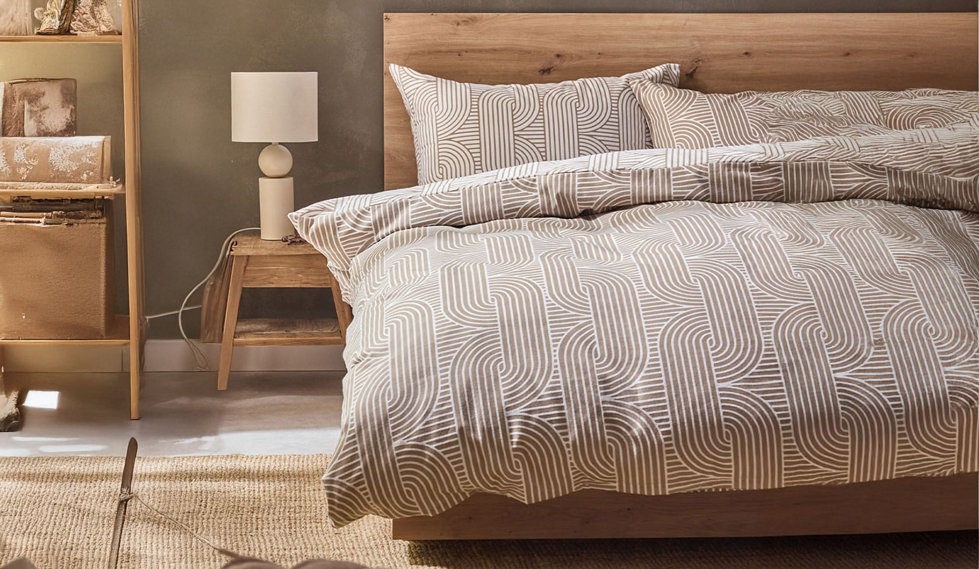 Bedroom with wooden bed, geometric pattern bedding, and nightstand with lamp.
