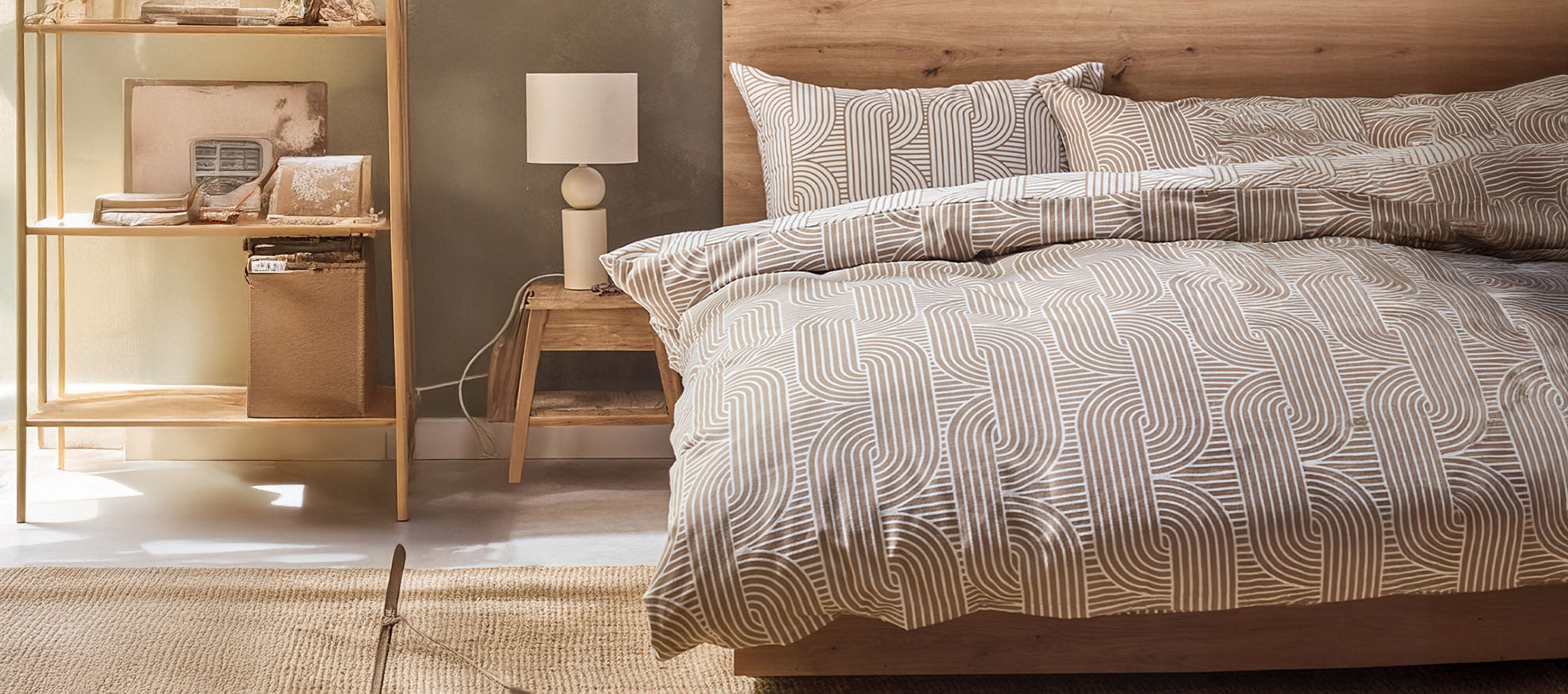 Bedroom with wooden bed, patterned duvet cover, nightstand, and shelving unit.