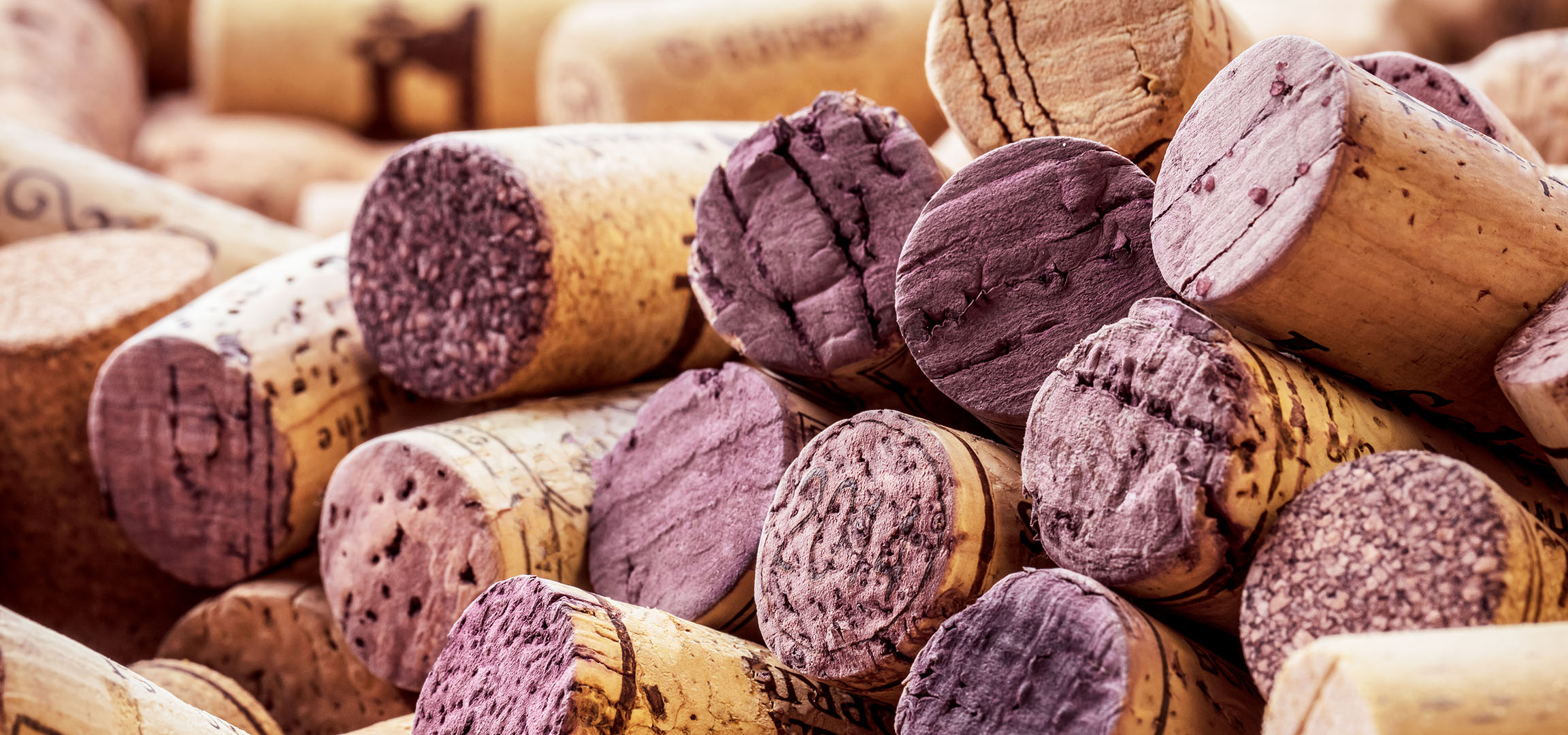 Close-up of wine corks, some stained red.