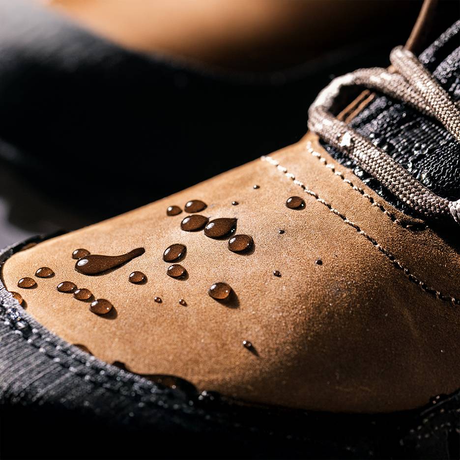 Waterproof brown shoes with water droplets on the surface.