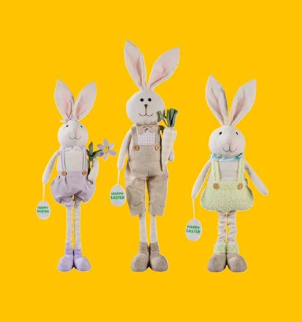 Three Easter bunny plush toys in overalls, holding flowers and carrots, with 'Happy Easter' tags.