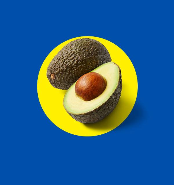 Whole and halved avocado with pit on a yellow circle against a blue background.