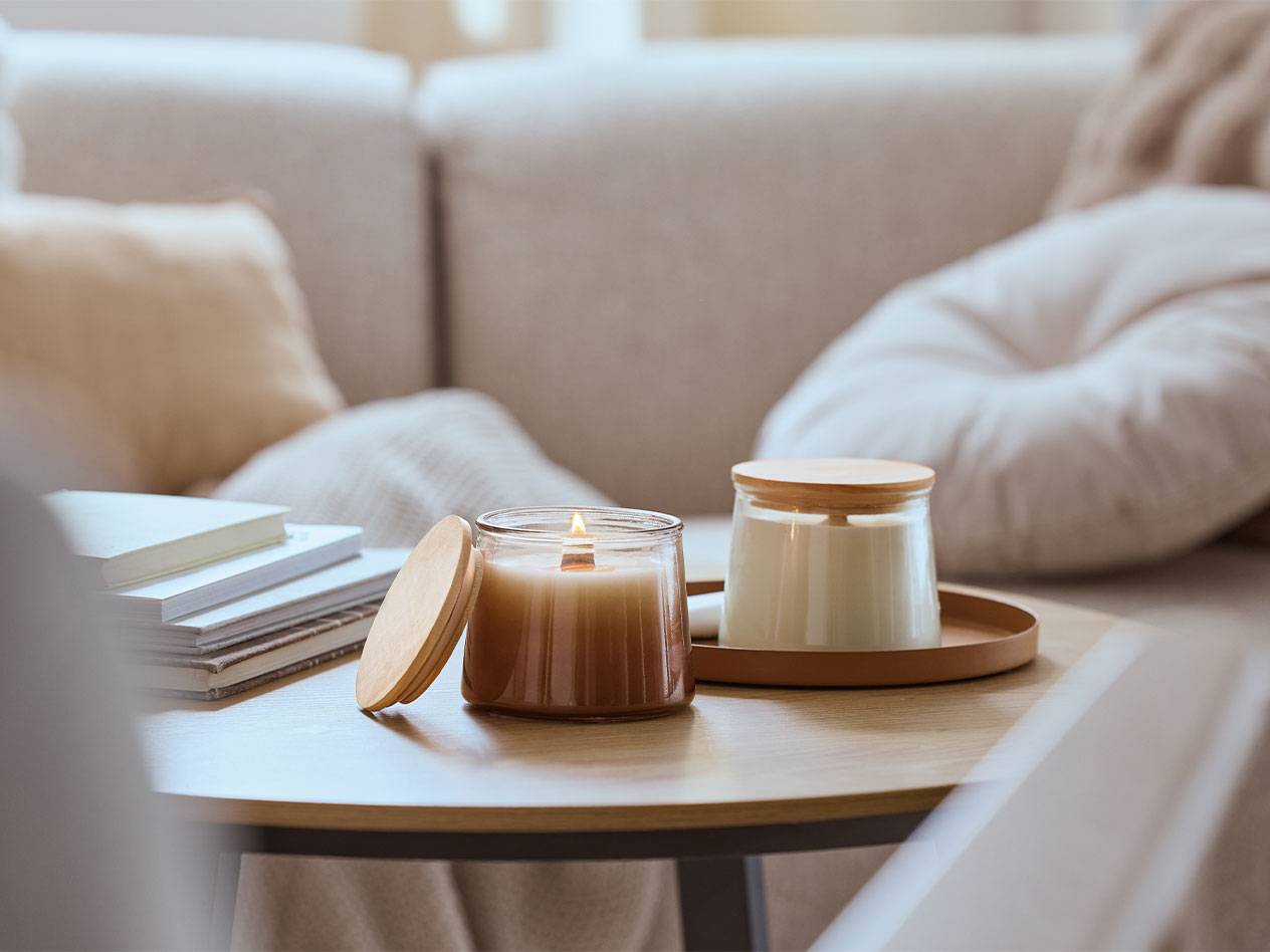 Two scented candles on a wooden coffee table in a living room