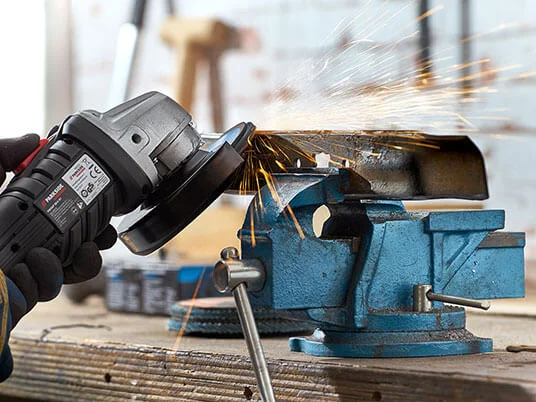 Parkside angle grinder in use, with sparks flying from a metal piece in a vice.