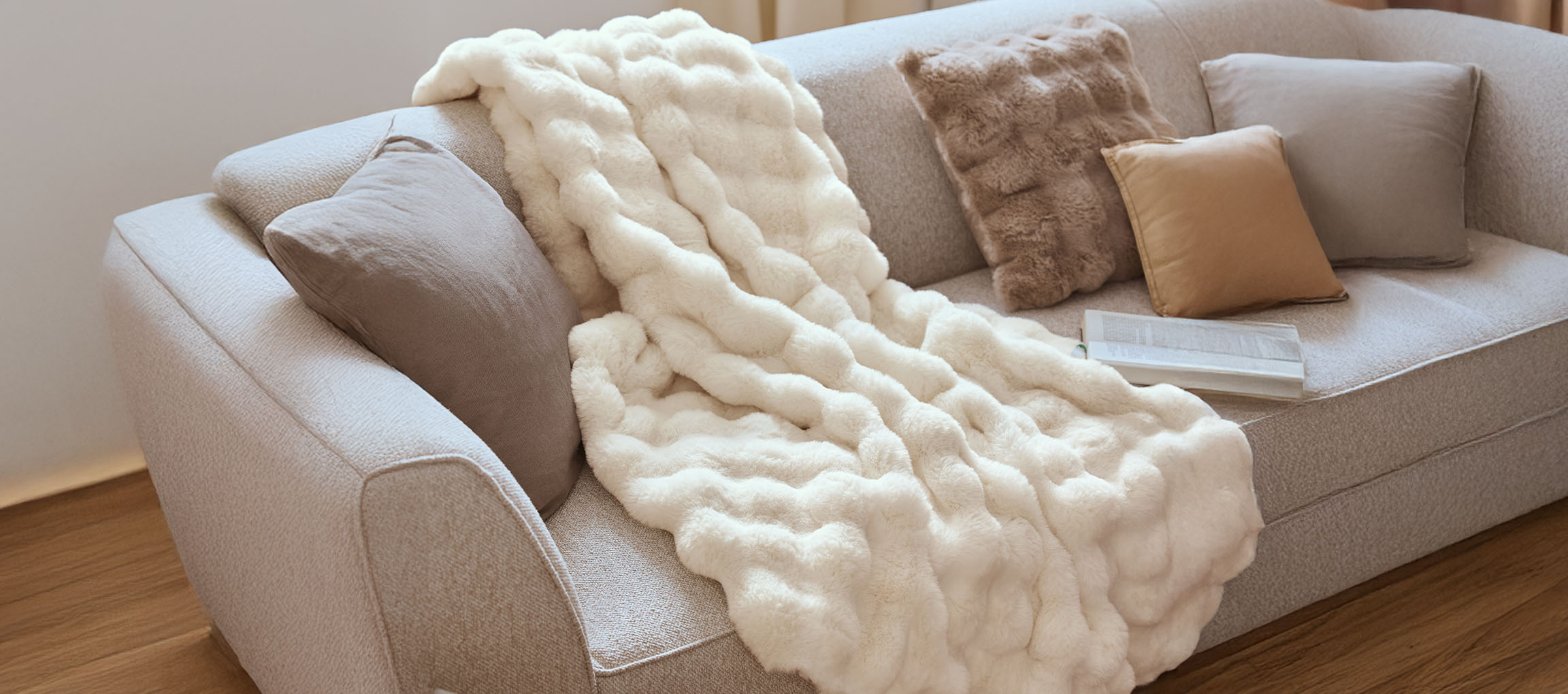 Cozy sofa with a white faux fur throw and decorative pillows.