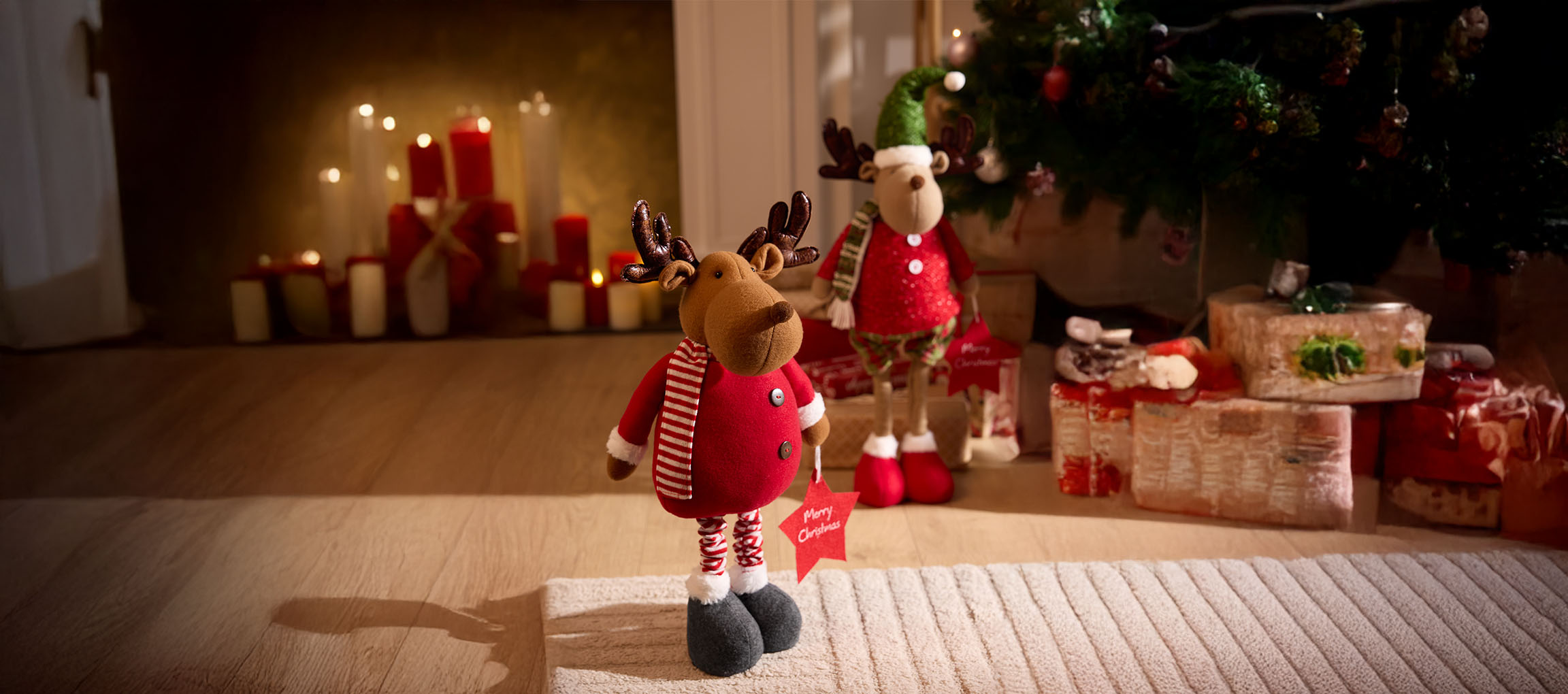 Christmas decorations: two reindeer, candles, and a Christmas tree with gifts.
