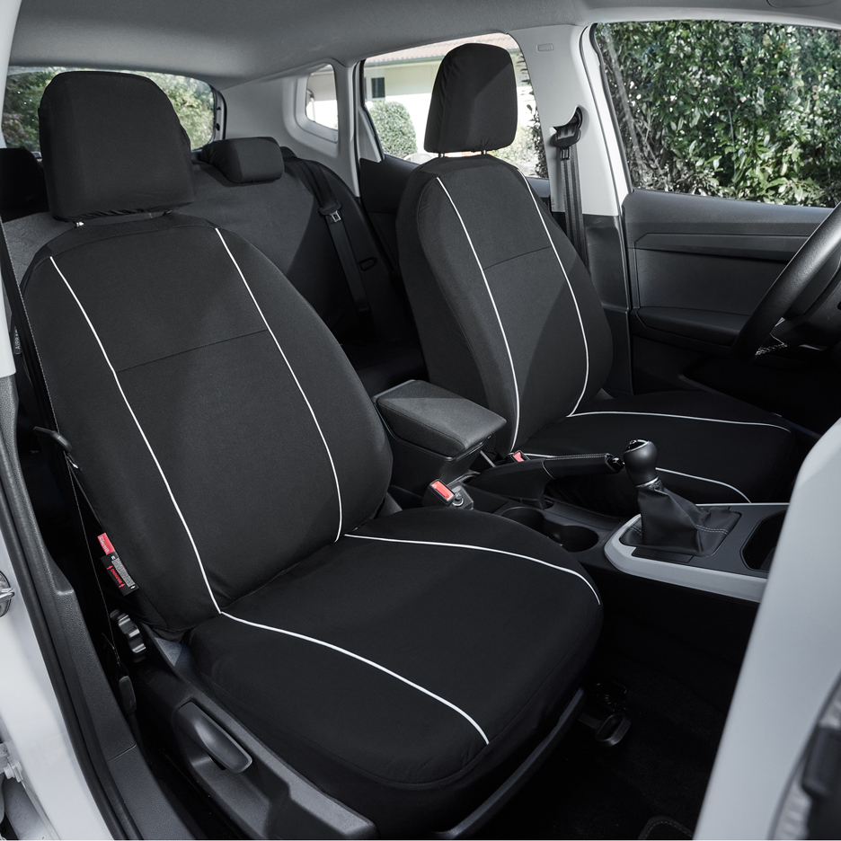 Black car seat covers with white detailing inside a car.