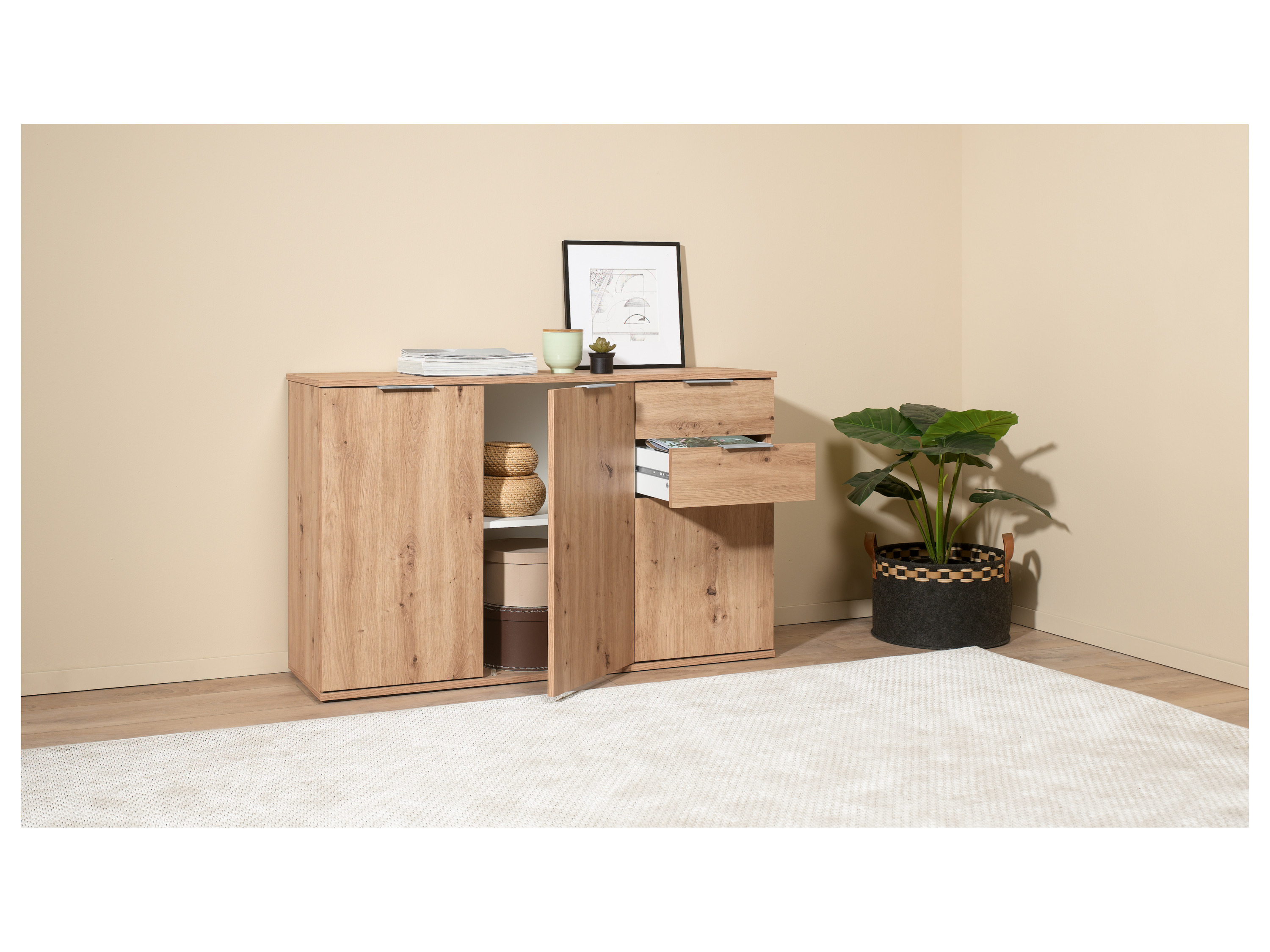 A light oak sideboard with two doors and two drawers, styled with home decor items.