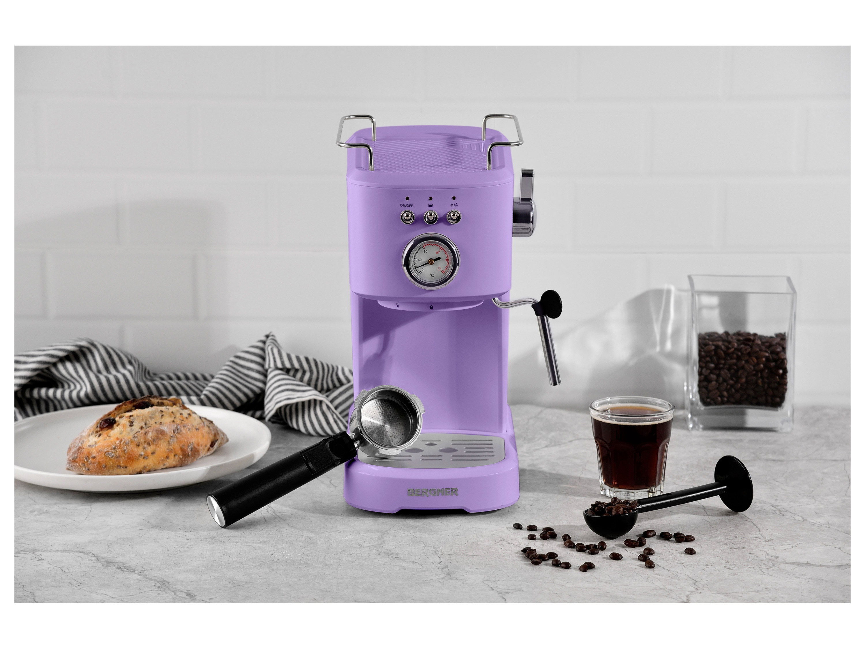 A purple Bergner espresso machine sits on a marble countertop with coffee beans, a cup of espresso, and a bread roll.