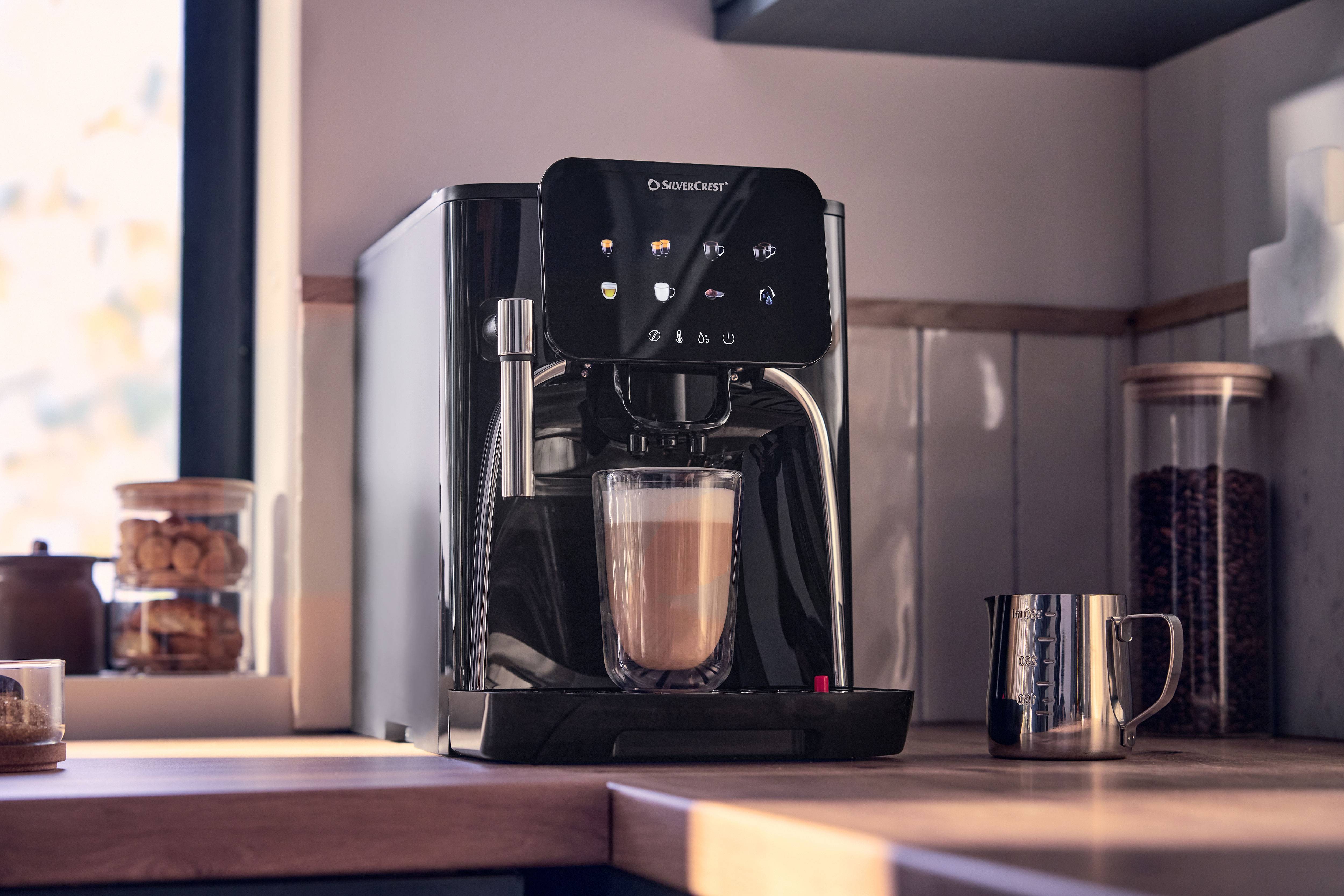 Coffee machine with a touchscreen preparing latte in a glass, on a wooden countertop.